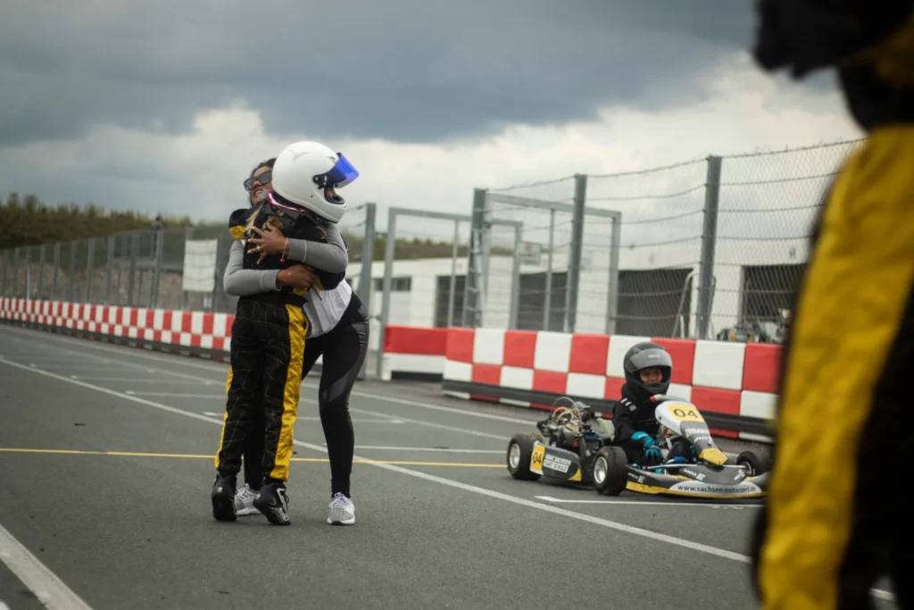 Kartfahrer umarmen sich auf Strecke vor Rennen